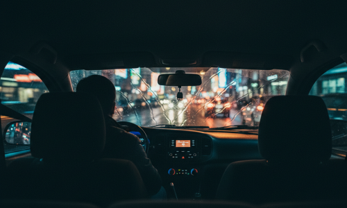 Firefly_Gemini Flash_Editorial-style photograph of a nighttime rideshare or taxi interior viewed from the 208943